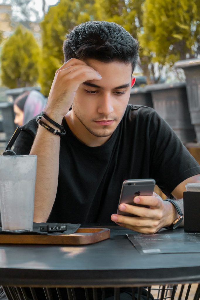 Uomo preoccupato che guarda il telefono