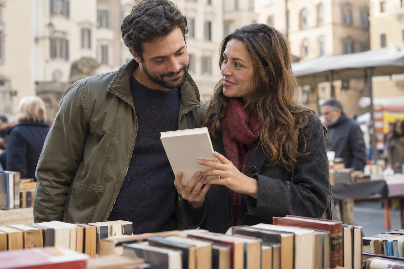 Due adulti sfogliano un libro insieme a un mercatino all'aperto