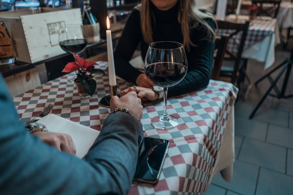 Coppia al tavolo di un ristorante che valuta la compatibilità dopo lo speed dating